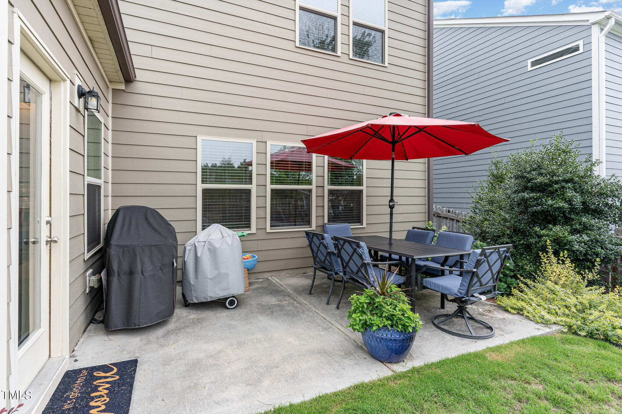 3405 Barn Road Apex, NC 27502 - Photo 32 of 38 a view of a patio with a table and chairs under an umbrella