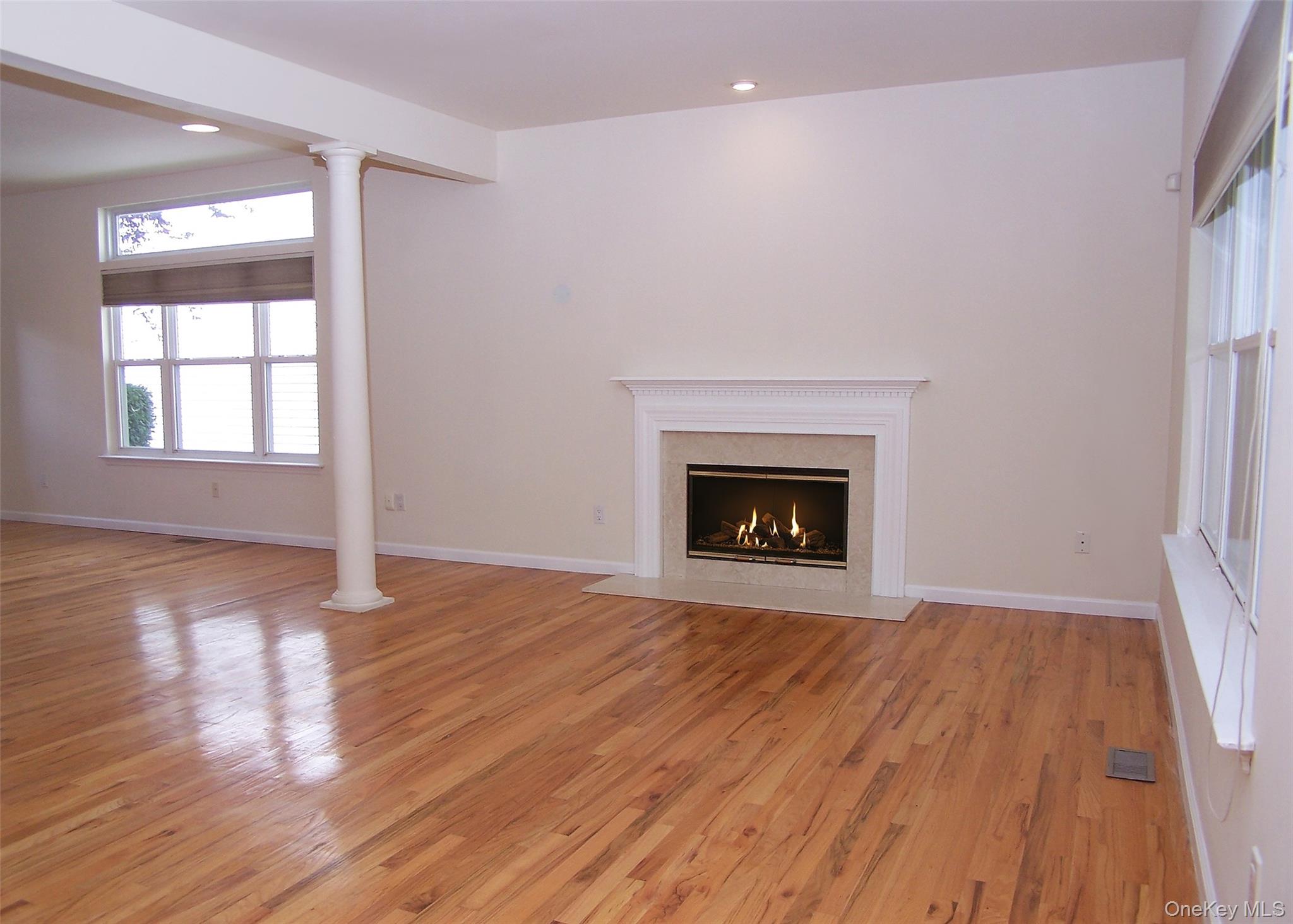 63 Sunflower Ridge Road Centereach, NY 11720 - Photo 4 of 24 wooden floor fireplace and windows in an empty room