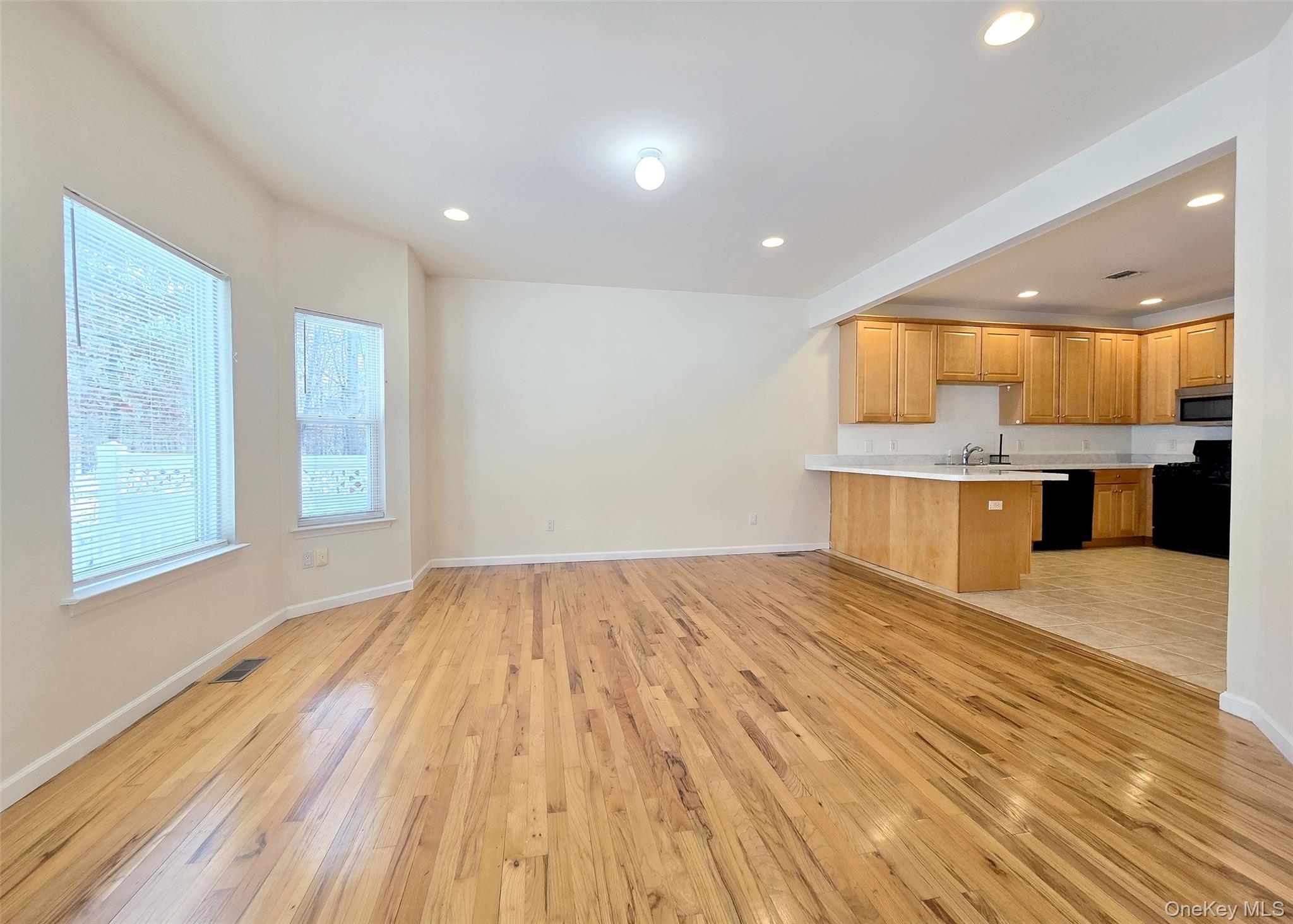 63 Sunflower Ridge Road Centereach, NY 11720 - Photo 7 of 23 a view of kitchen and empty room with wooden floor