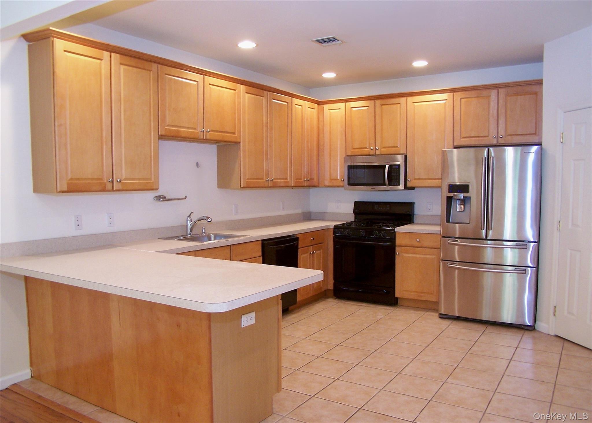 63 Sunflower Ridge Road Centereach, NY 11720 - Photo 7 of 24 a kitchen with stainless steel appliances granite countertop a refrigerator sink and stove