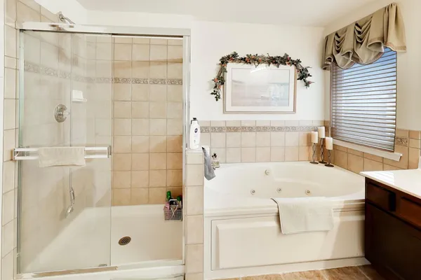 a white bath tub sitting next to a white sink and a shower