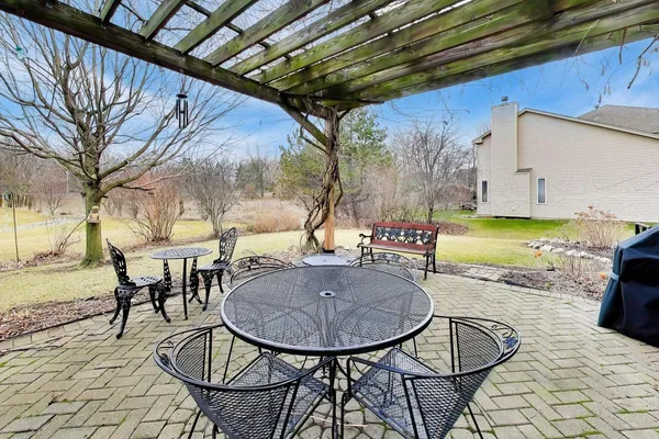 a backyard of a house with barbeque oven table and chairs