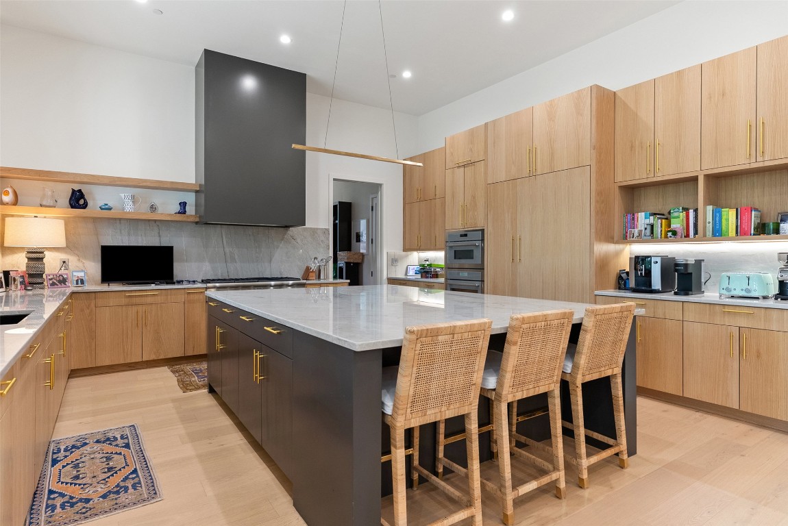 304 Blue Ridge Trail Austin, TX 78746 - Photo 21 of 40 a kitchen with kitchen island granite countertop a sink and a stove