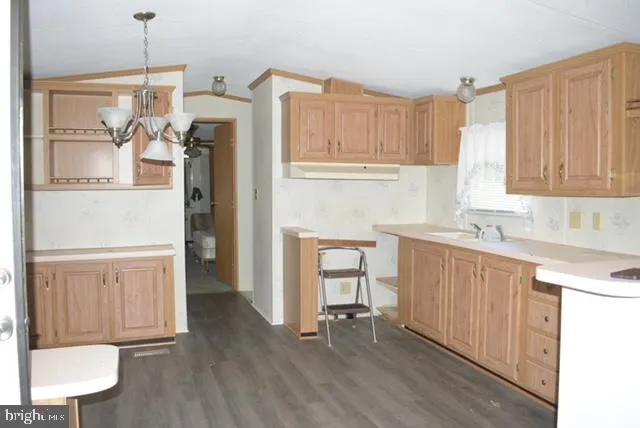 a kitchen with stainless steel appliances granite countertop a refrigerator a sink dishwasher and white cabinets with wooden floor