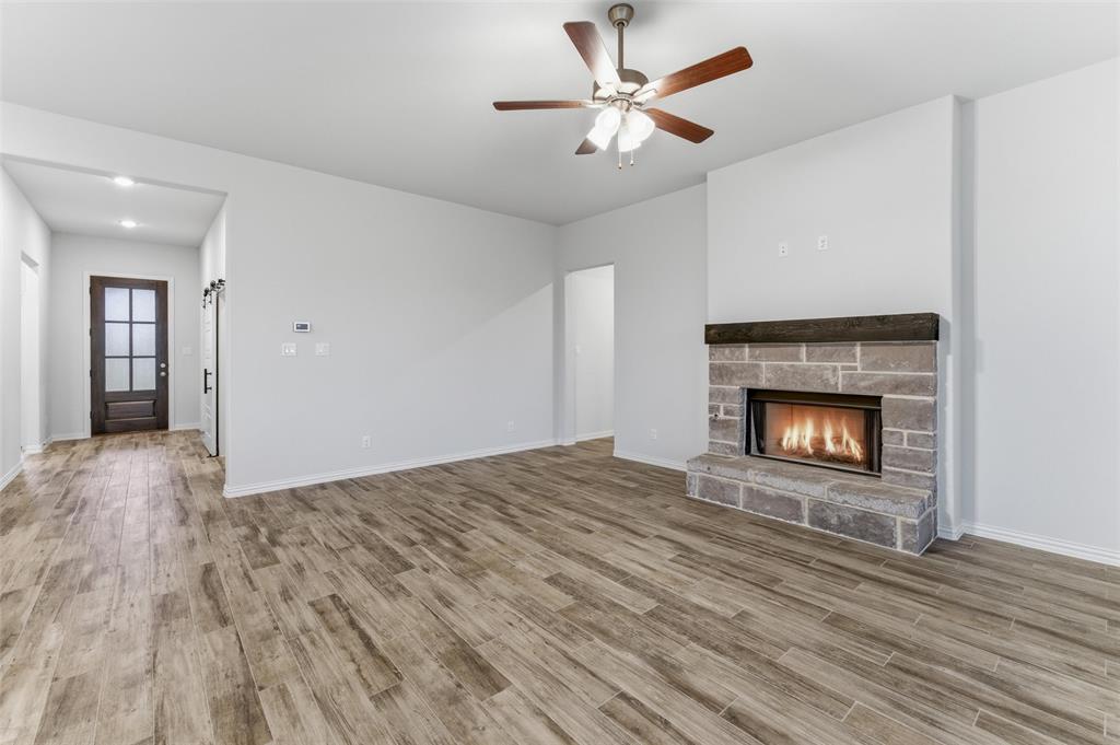 119 Hillview Trail Decatur, TX 76234 - Photo 22 of 30 Living area featuring wood-finish flooring and a stone-clad fireplace with a dark wood mantel