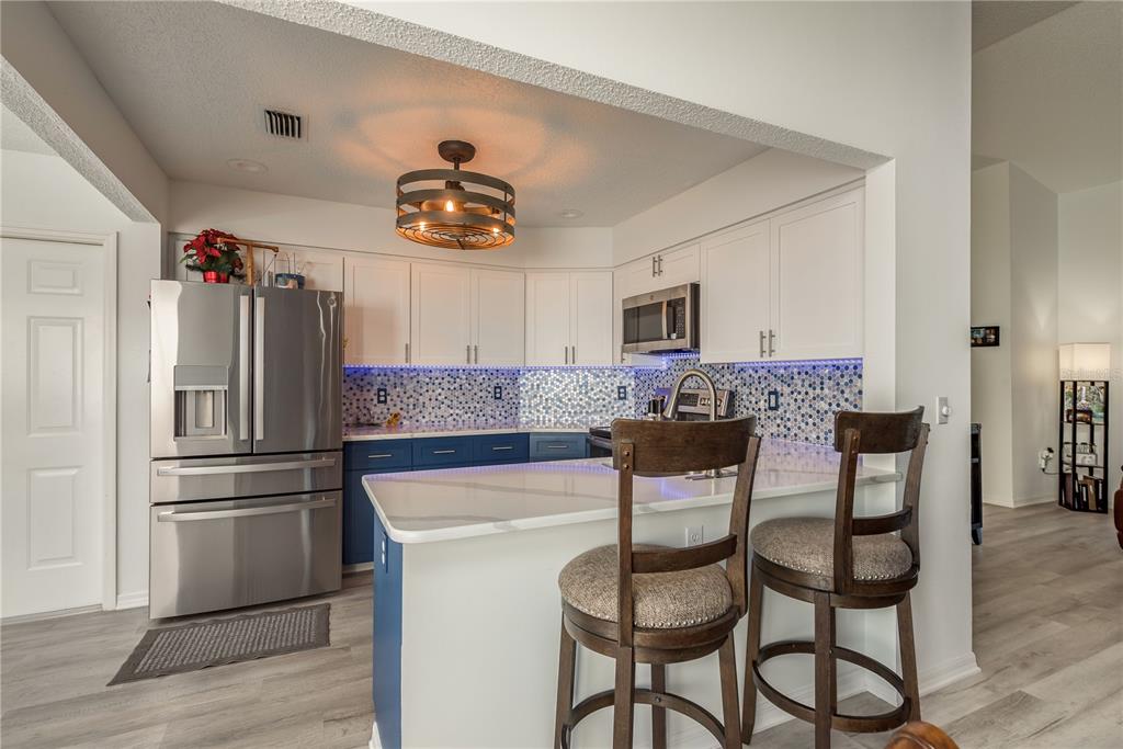 7536 Roland Court New Port Richey, FL 34654 - Photo 5 of 15 a kitchen with stainless steel appliances a refrigerator and a stove top oven