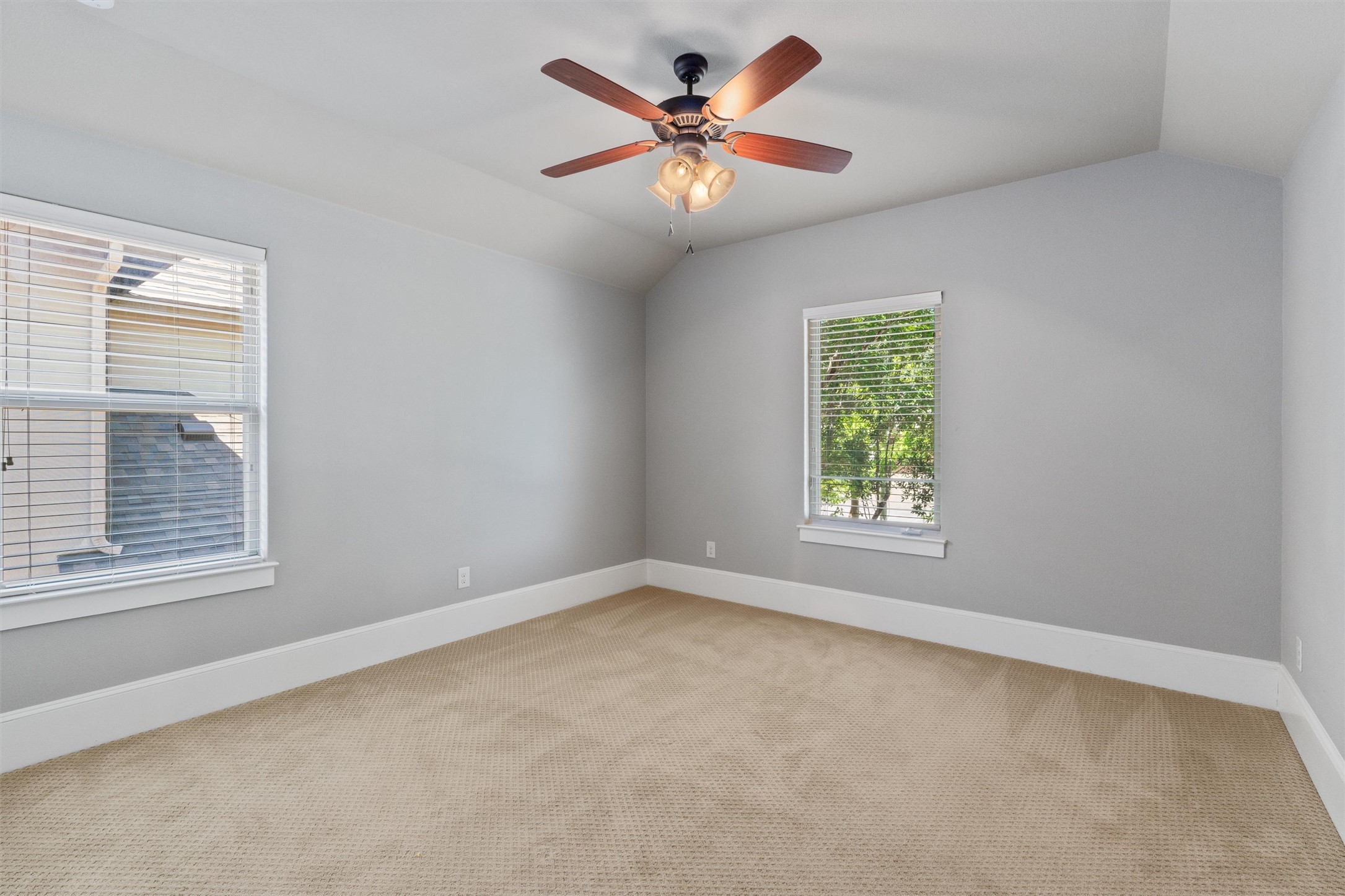 8417 Etienne Cove Austin, TX 78759 - Photo 26 of 35 A well-lit bedroom features vaulted ceilings and plush carpet, creating a serene personal retreat.