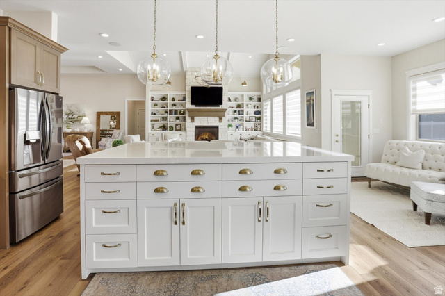 534 East Fish Hatchery Road Mantua, UT 84324 - Photo 86 of 87 Kitchen featuring open floor plan, stainless steel fridge, a chandelier, and a lit fireplace