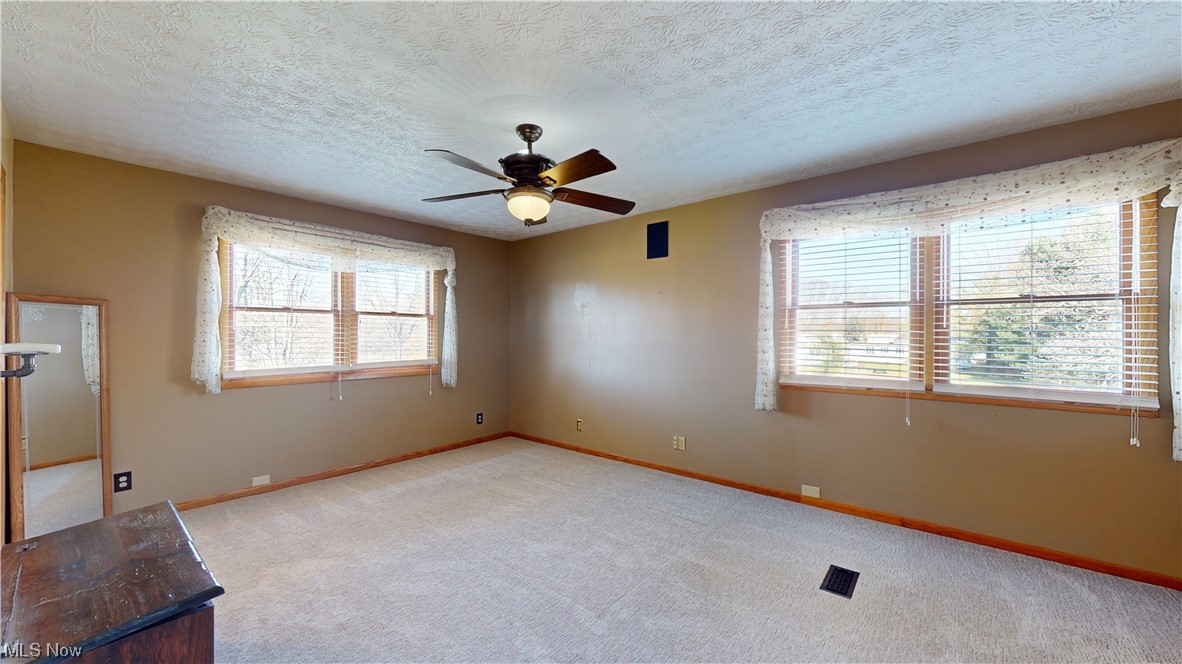 6755 State Rte 5 Ravenna, OH 44266 - Photo 19 of 34 Unfurnished living room with ceiling fan, light colored carpet, and a textured ceiling