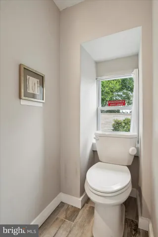 a bathroom with a toilet and a window