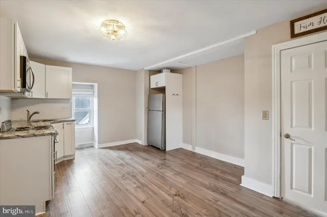 a view of a kitchen with a stove wooden floor and a kitchen