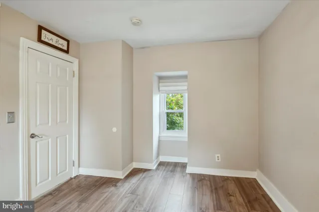 an empty room with wooden floor and a window