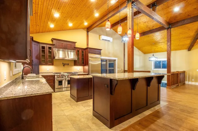 a kitchen with stainless steel appliances granite countertop a sink and a stove