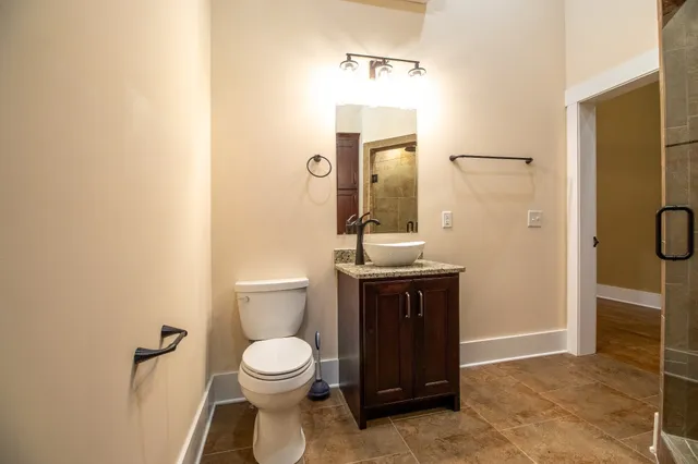 a bathroom with a toilet a sink and mirror