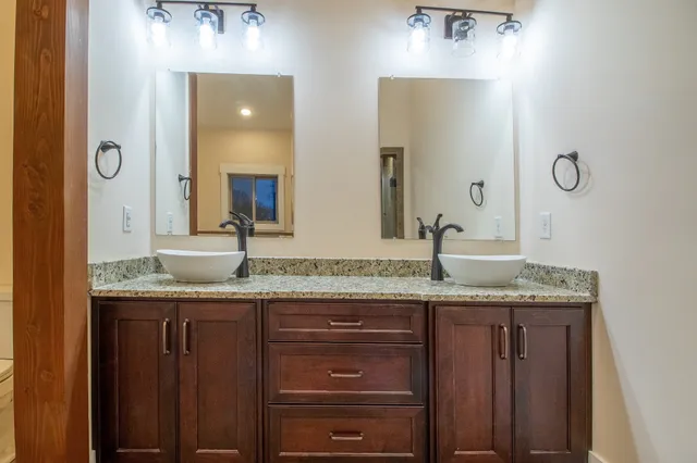 a bathroom with a granite countertop sink and a mirror