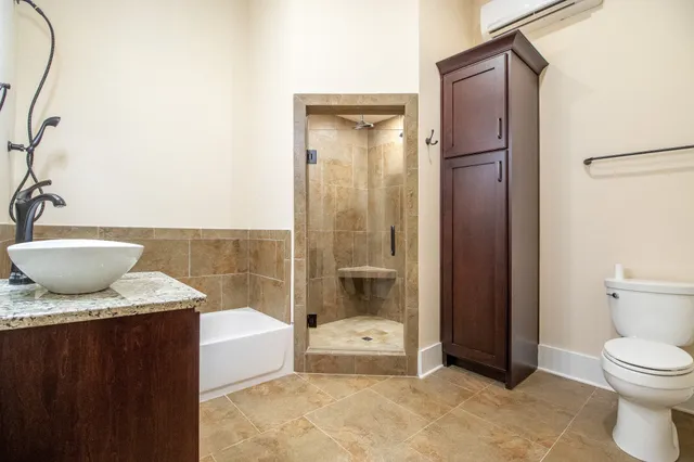 a bathroom with a granite countertop sink toilet and shower