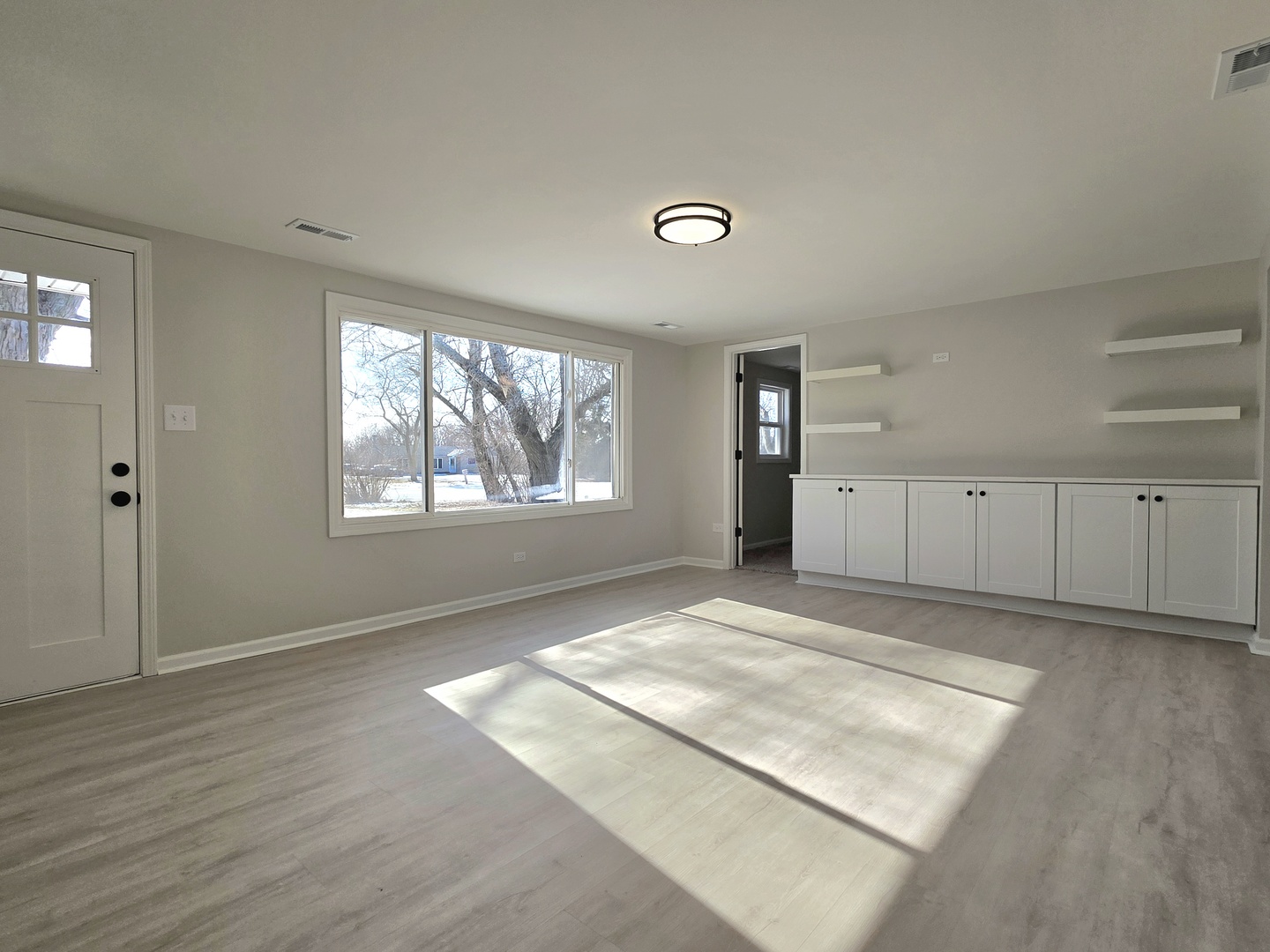 946 West Arlington Lane Crete, IL 60417 - Photo 8 of 27 a view of an empty room with wooden floor and a window