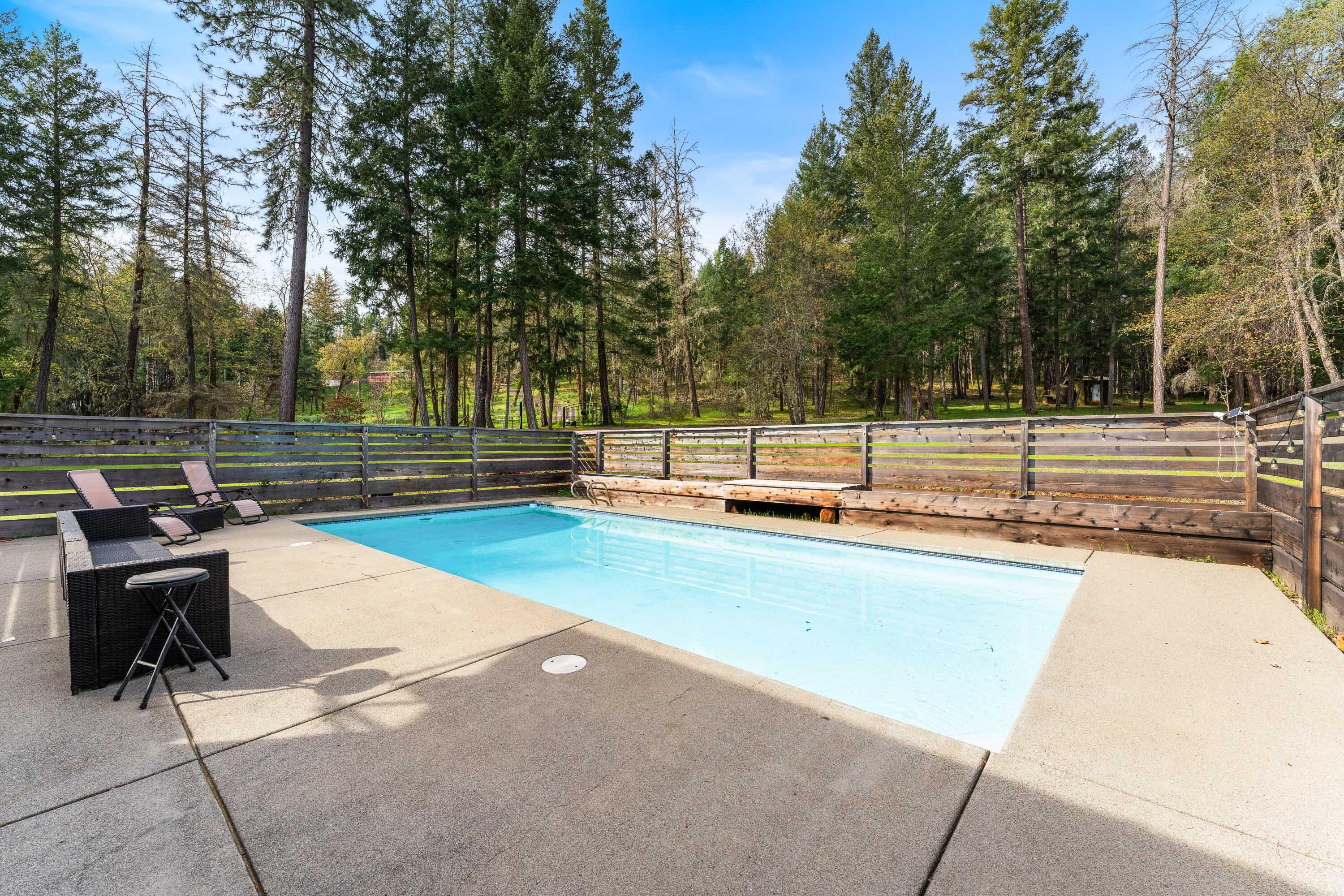 7201 Crowfoot Road Trail, OR 97541 - Photo 32 of 56 a view of a swimming pool with a bench and trees around