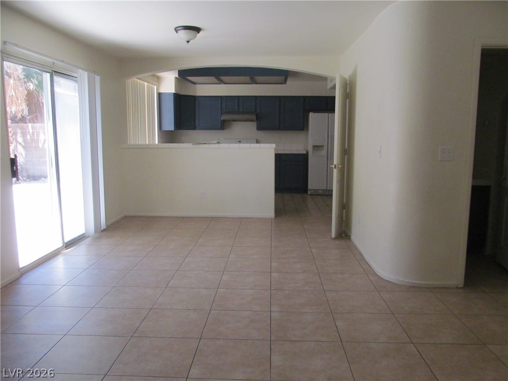 8701 Crescent Ridge Lane Las Vegas, NV 89134 - Photo 7 of 28 A flowing layout with sleek tile flooring connects the living area to a modern kitchen.