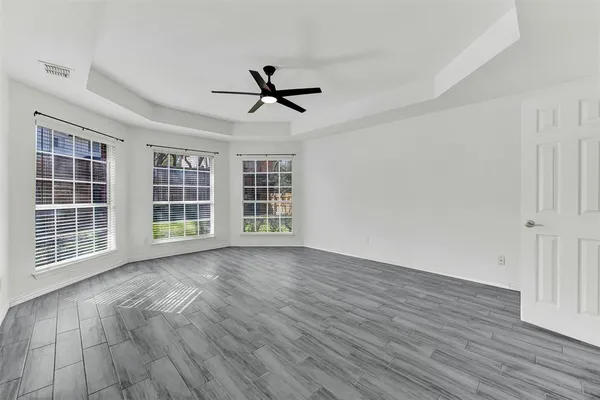 a view of empty room with wooden floor and windows