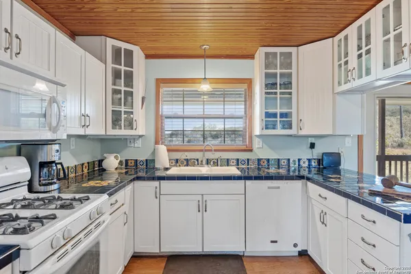 a kitchen with stainless steel appliances granite countertop a sink a stove and cabinets