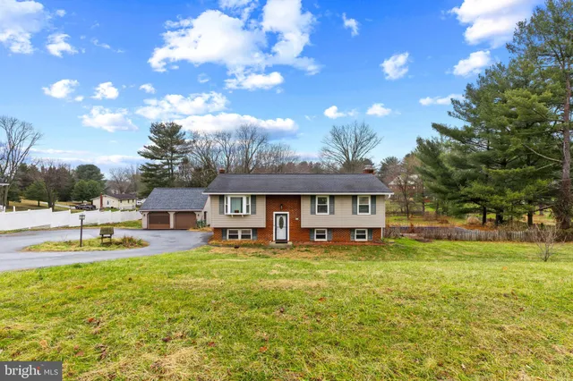 a view of a house with a big yard and a large tree