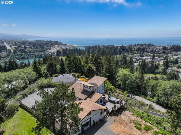 an aerial view of a house with a yard and lake view