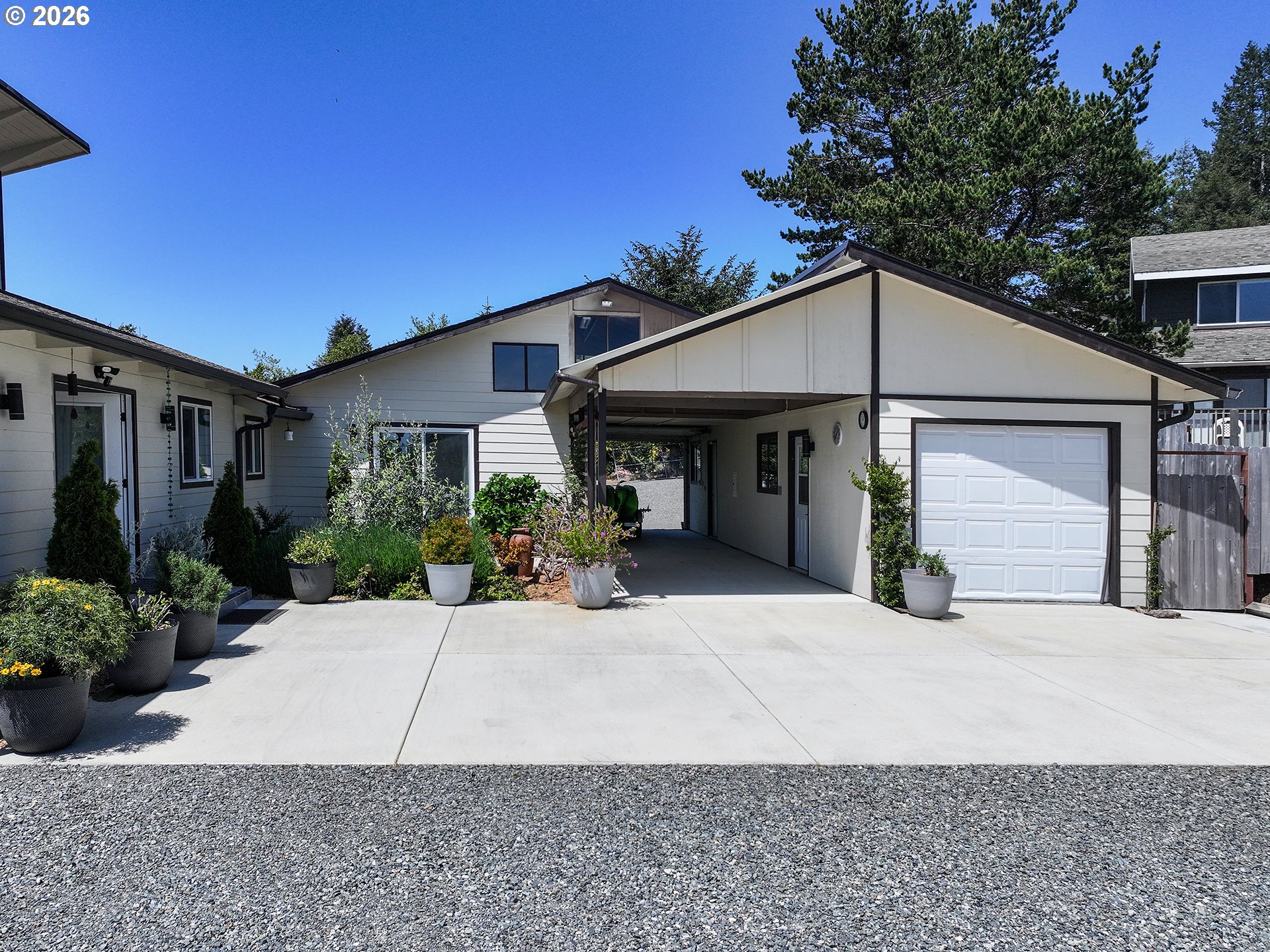 895 Marina Heights Road Brookings, OR 97415 - Photo 43 of 48 a front view of a house with a yard and potted plants