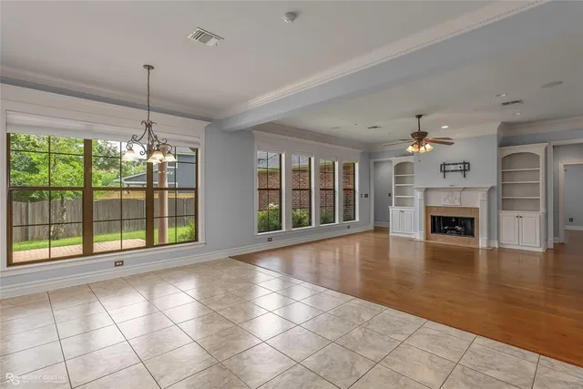 a view of an empty room with window wooden floor and a kitchen