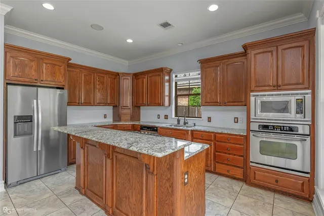 a kitchen with stainless steel appliances granite countertop a stove refrigerator sink and cabinets