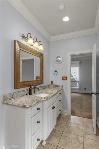a bathroom with a granite countertop sink vanity and mirror