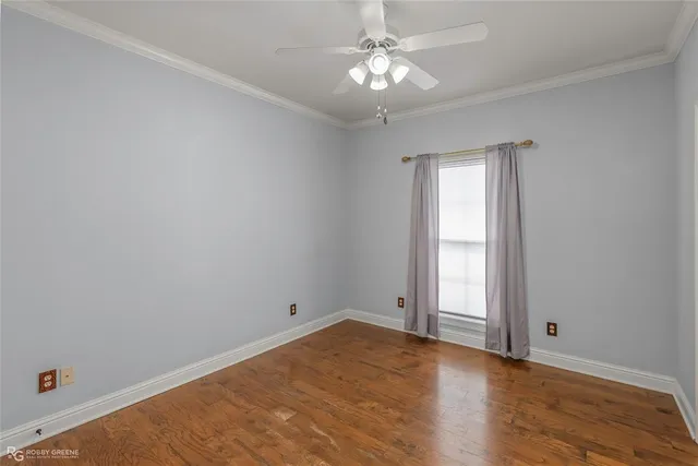 an empty room with wooden floor and window