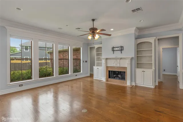 a view of an empty room with a fireplace and a window