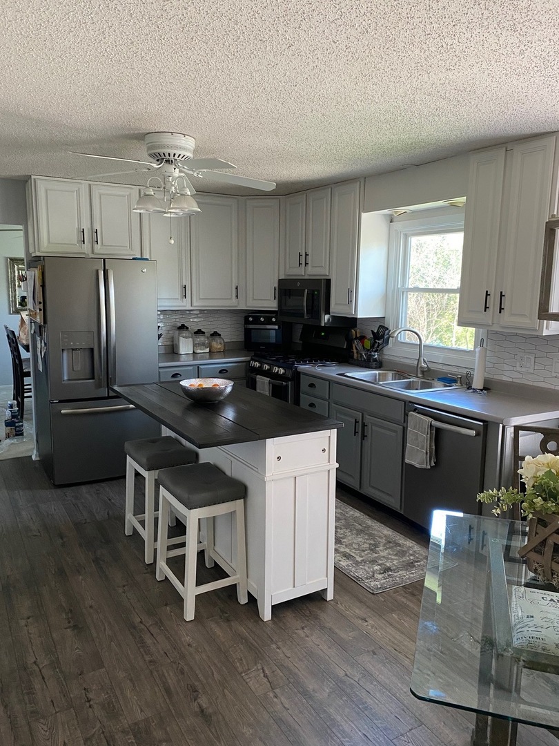 999 Confederation Drive Bartlett, IL 60103 - Photo 7 of 26 a kitchen with stainless steel appliances a sink a stove a refrigerator cabinets and wooden floor