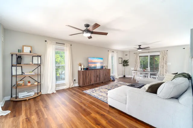 a living room with furniture a ceiling fan and a window