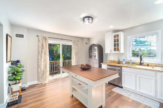 a view of a kitchen area with furniture and wooden floor