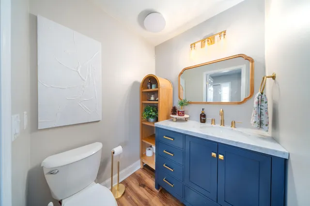 a bathroom with a toilet sink vanity and mirror