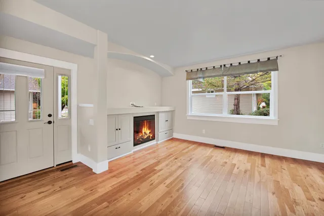 a view of empty room with a fireplace and wooden floor