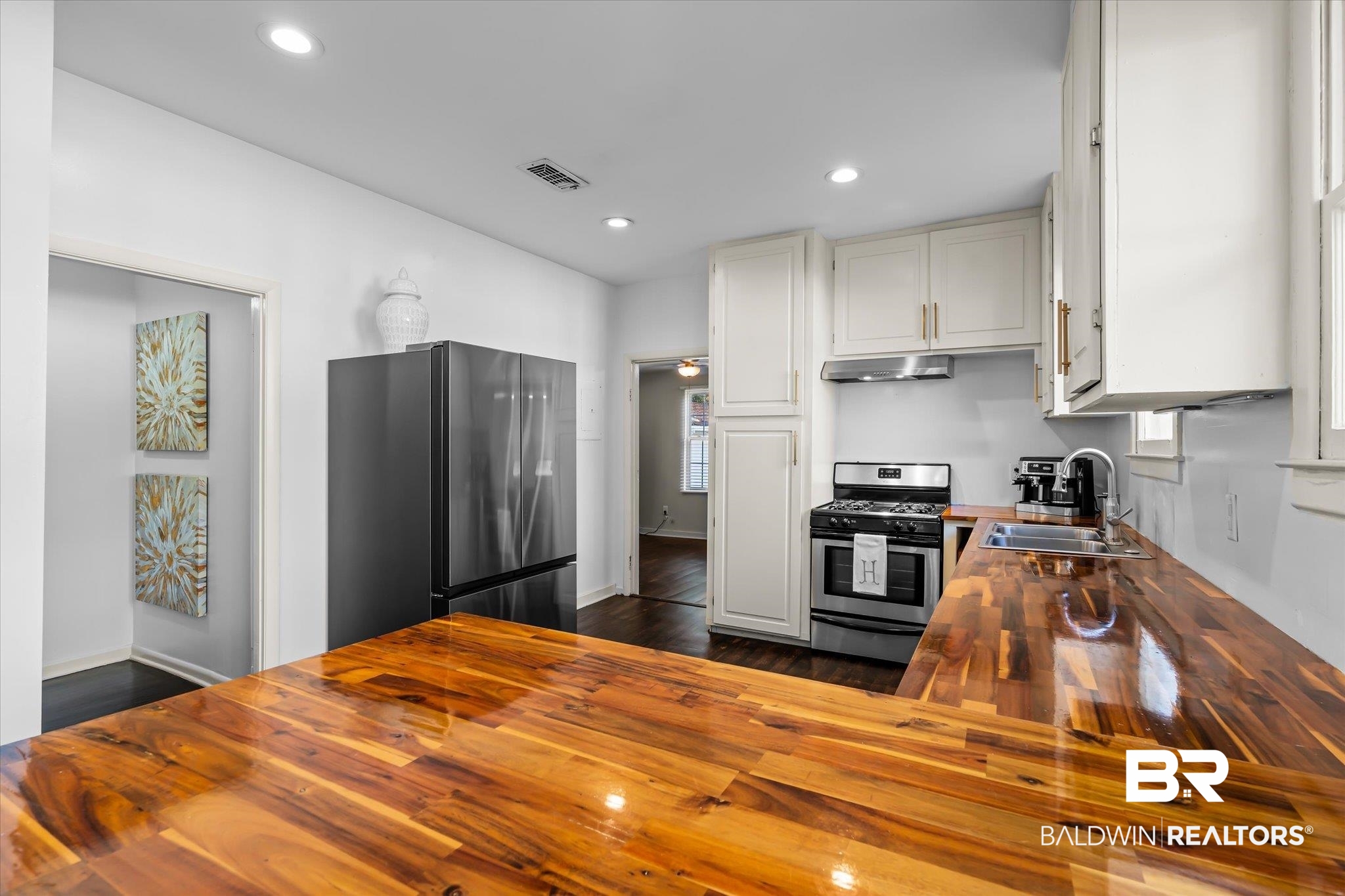 180 Williams Street Mobile, AL 36606 - Photo 10 of 20 Kitchen with wooden counters, appliances with stainless steel finishes, white cabinetry, and sink