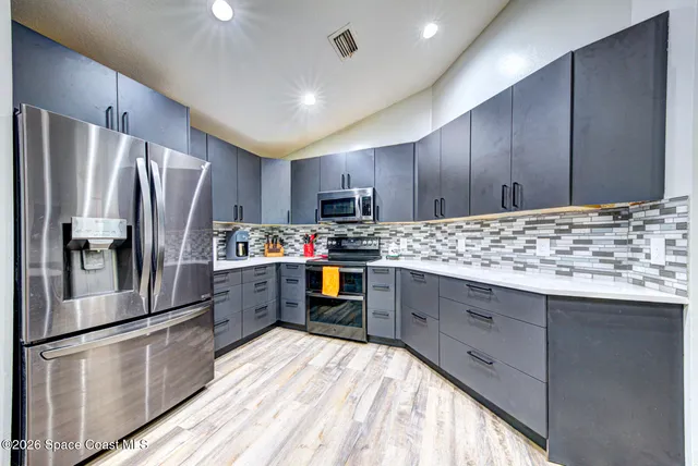 a kitchen with granite countertop stainless steel appliances and refrigerator
