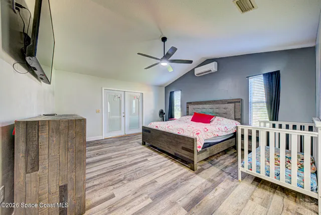 a bedroom with a bed and a flat screen tv