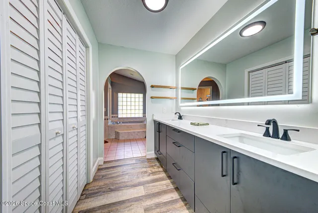a hallway with a sink and a large mirror