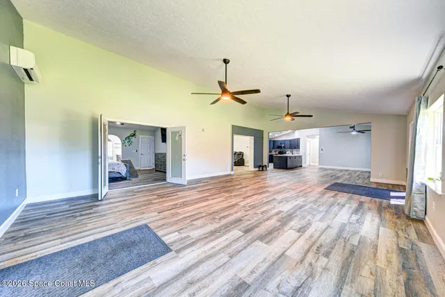 a view of a livingroom with wooden floor and a ceiling fan