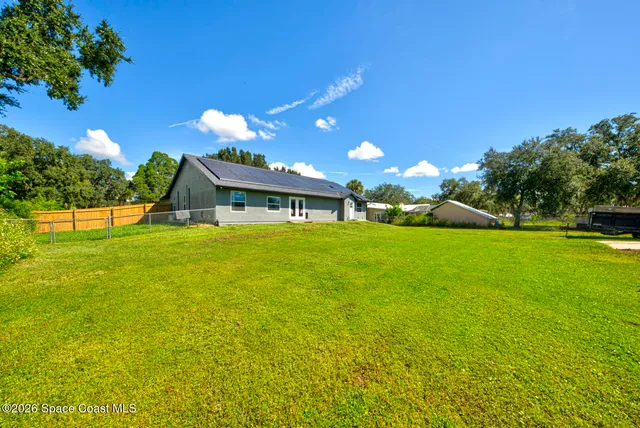 a view of a big yard with swimming pool and green space