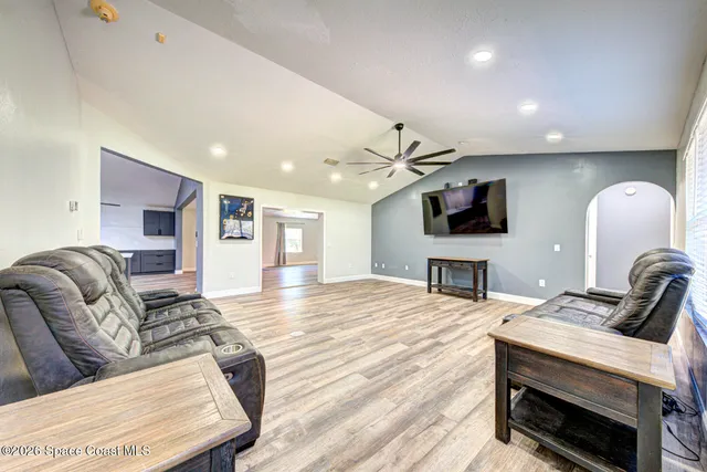 a living room with furniture a flat screen tv and a fireplace