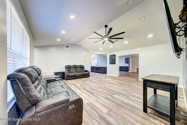 a living room with furniture and a wooden floor