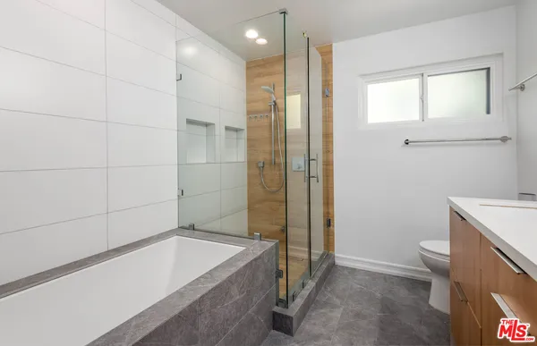 a bathroom with a tub a toilet and a shower
