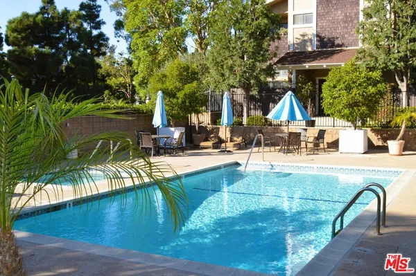 a view of a swimming pool with a patio and a yard