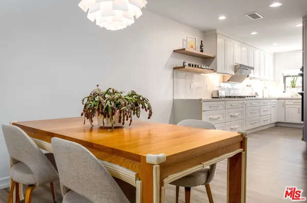 a kitchen with stainless steel appliances a table and chairs in it