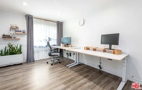 a view of a workspace with furniture and a window
